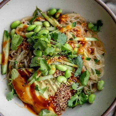 Plate of cold sesame miso noodles garnished with vegetables and sesame seeds