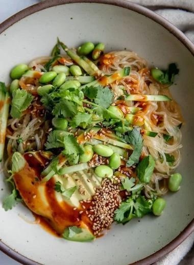 Plate of cold sesame miso noodles garnished with vegetables and sesame seeds