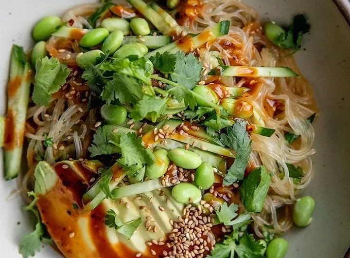 Plate of cold sesame miso noodles garnished with vegetables and sesame seeds