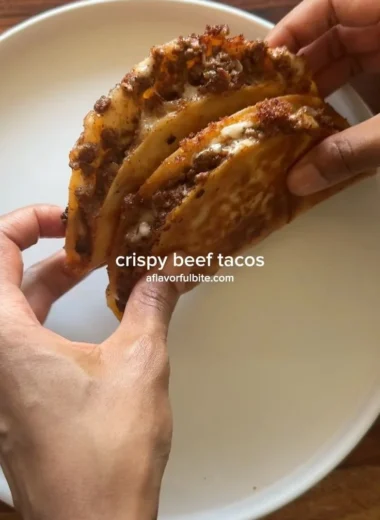 Plate of crispy ground beef tacos with fresh toppings