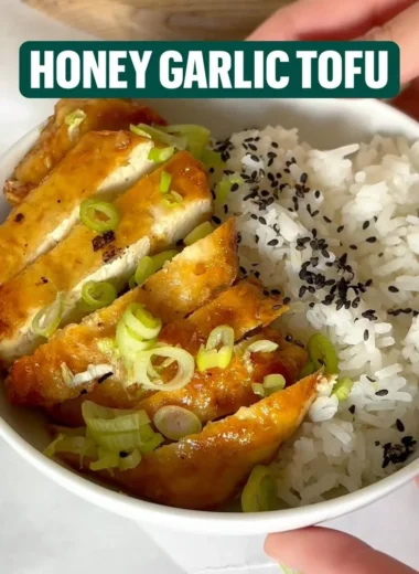 Plate of Honey Garlic Tofu garnished with green onions and sesame seeds
