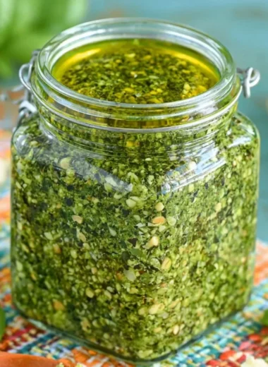 Fresh basil pesto served in a bowl with pine nuts and olive oil
