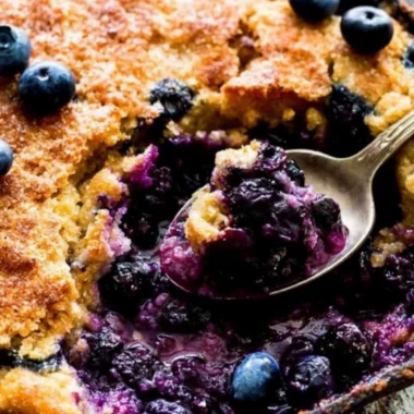 Delicious homemade blueberry cobbler topped with crispy crust and fresh blueberries