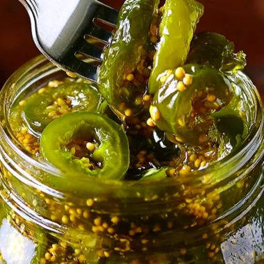 Jars of homemade Cowboy Candy showcased on a rustic wooden table.