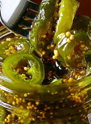 Jars of homemade Cowboy Candy showcased on a rustic wooden table.