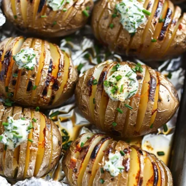 Hasselback potatoes with melted chive butter served on a plate