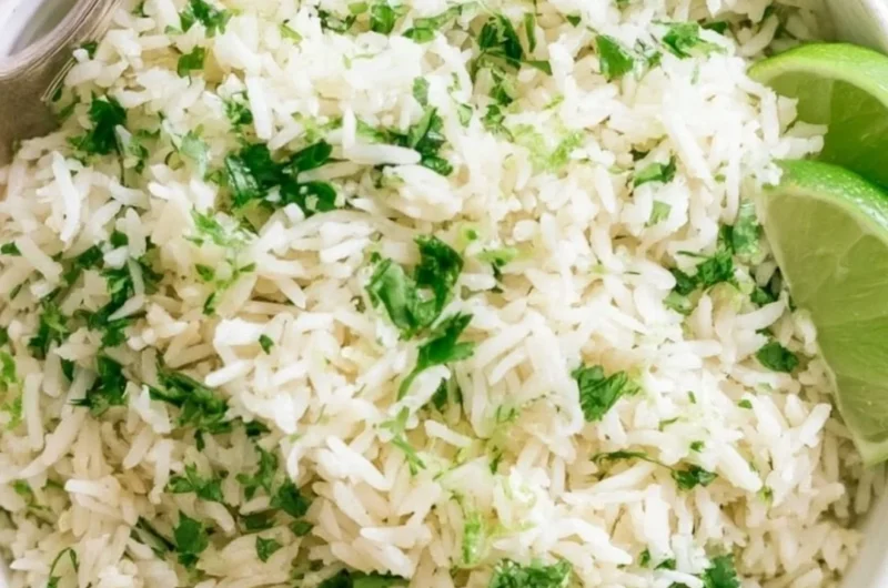 Bowl of homemade cilantro lime rice with fresh cilantro and lime wedges