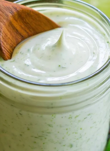 Bottle of homemade jalapeno ranch dressing with fresh ingredients