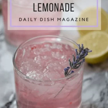 A refreshing glass of pink lavender lemonade garnished with fresh lavender sprigs.