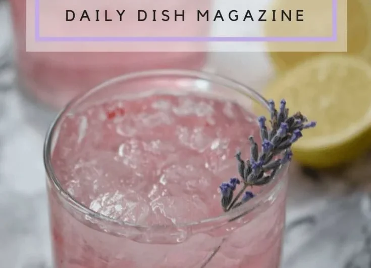 A refreshing glass of pink lavender lemonade garnished with fresh lavender sprigs.