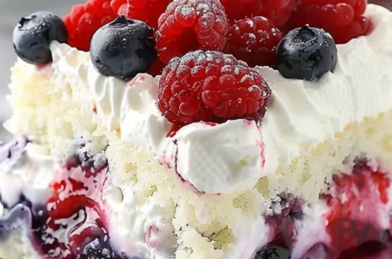 Delicious Summer Berry Poke Cake topped with fresh berries and whipped cream