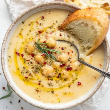 Bowl of Vegan Garlic Chickpea Soup garnished with fresh herbs