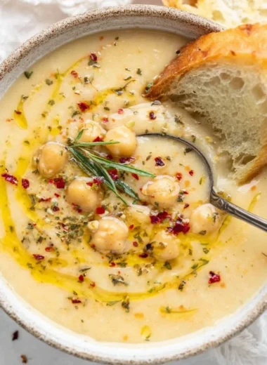 Bowl of Vegan Garlic Chickpea Soup garnished with fresh herbs