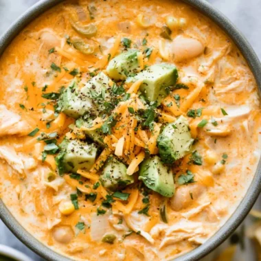 Bowl of creamy white chicken chili garnished with cilantro and lime