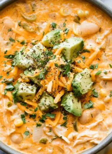 Bowl of creamy white chicken chili garnished with cilantro and lime