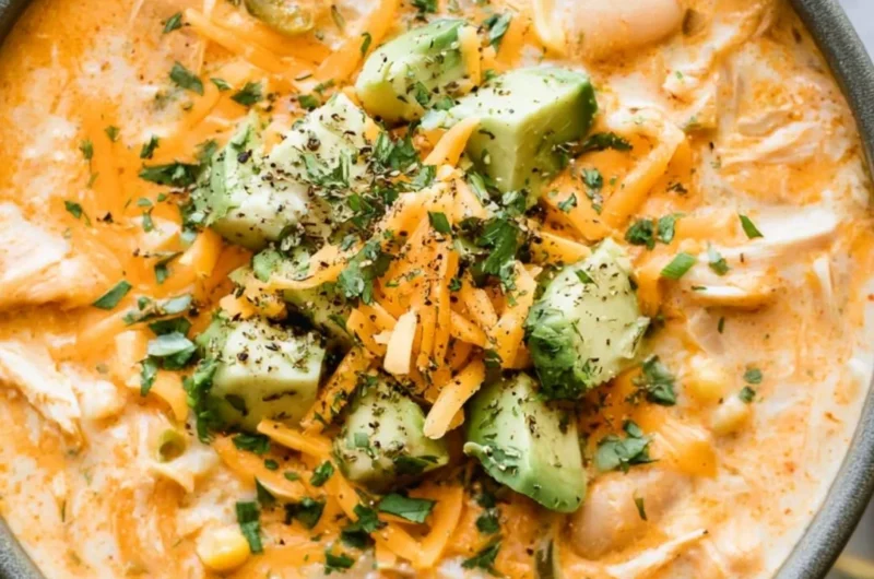 Bowl of creamy white chicken chili garnished with cilantro and lime