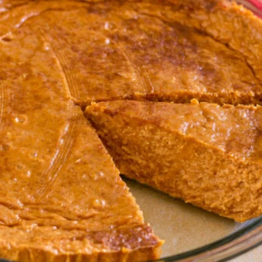 Cozy crustless pumpkin pie served on a rustic table with autumn decorations.
