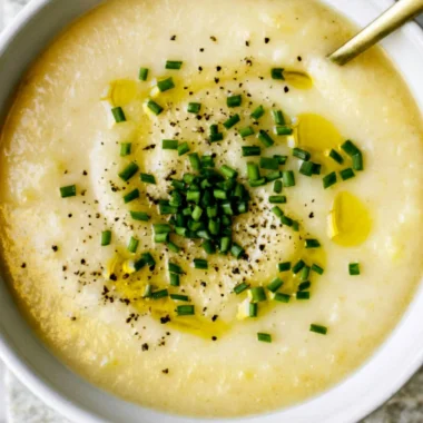 Creamy potato leek soup served in a bowl with fresh herbs.