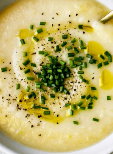 Creamy potato leek soup served in a bowl with fresh herbs.