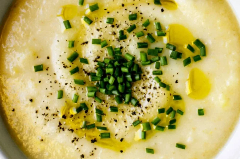 Creamy potato leek soup served in a bowl with fresh herbs.