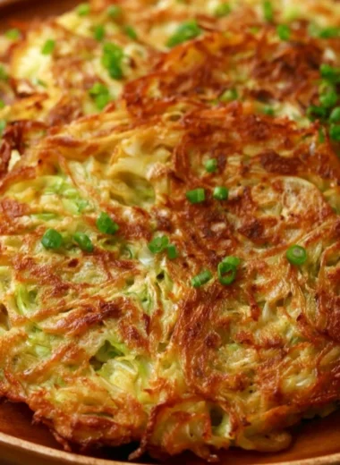Crispy cabbage pancakes served on a plate, garnished with herbs