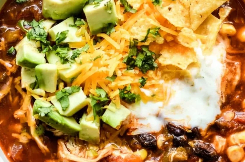 Bowl of delicious Crockpot chicken enchilada soup topped with cheese and cilantro