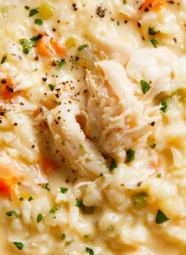 Bowl of creamy chicken rice soup topped with herbs and spices