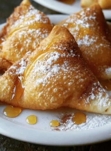 Fluffy sopaipillas served with honey on a plate