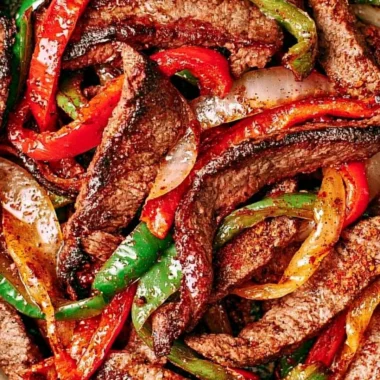 Delicious steak fajitas served with colorful peppers and onions