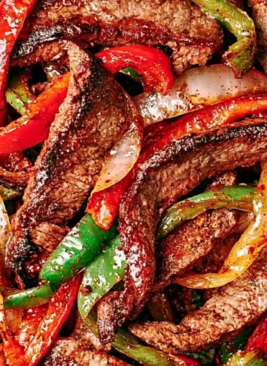 Delicious steak fajitas served with colorful peppers and onions