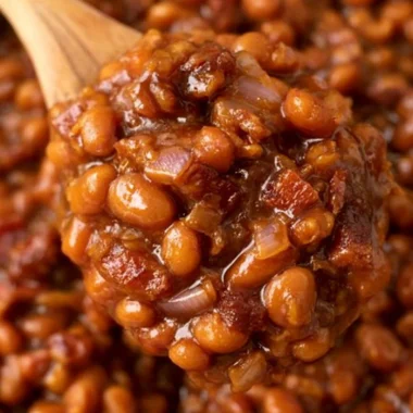 Delicious ultimate baked beans in a rustic bowl next to ingredients