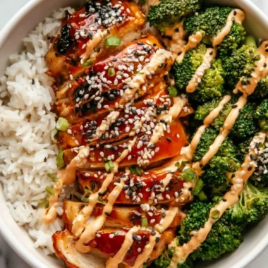 Healthy sticky chicken bowls topped with fresh vegetables and delicious sauce