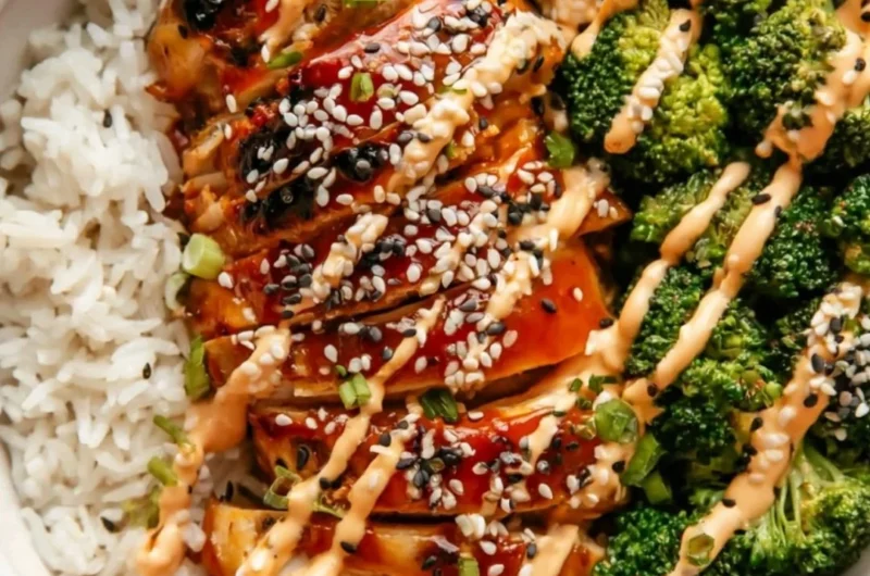 Healthy sticky chicken bowls topped with fresh vegetables and delicious sauce